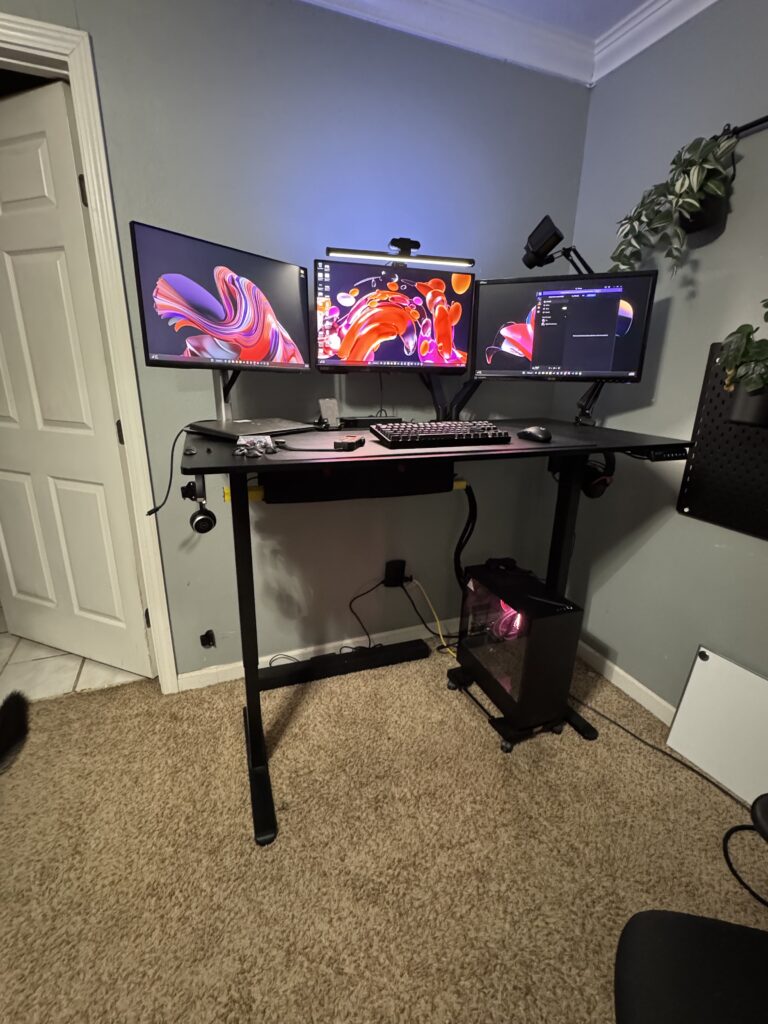 Eric’s desk with three monitors